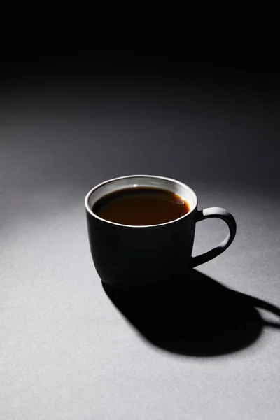 Chávena cheia de café na superfície texturizada escura — Fotografia de Stock