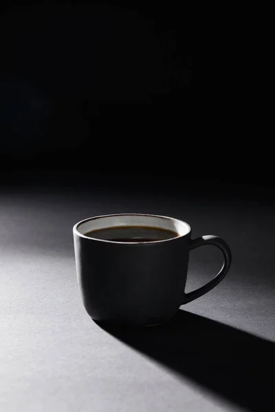 Kaffeetasse auf dunkler strukturierter Oberfläche auf schwarz — Stockfoto