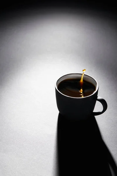 Copa llena de café con gota en la superficie de textura oscura - foto de stock