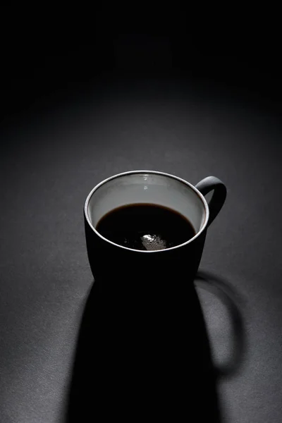 Cup of black coffee on dark textured surface — Stock Photo
