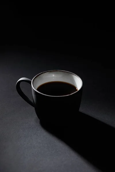 Tasse de café noir sur surface texturée foncée — Photo de stock