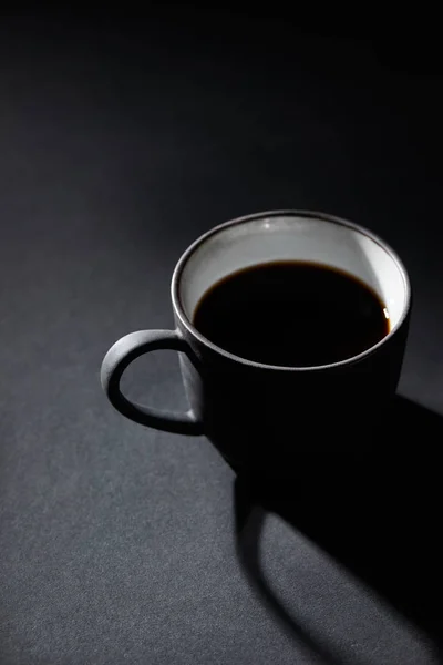 Cup of black coffee on dark textured surface — Stock Photo