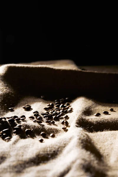 Concentration sélective des grains de café torréfiés sur la texture du sac — Photo de stock