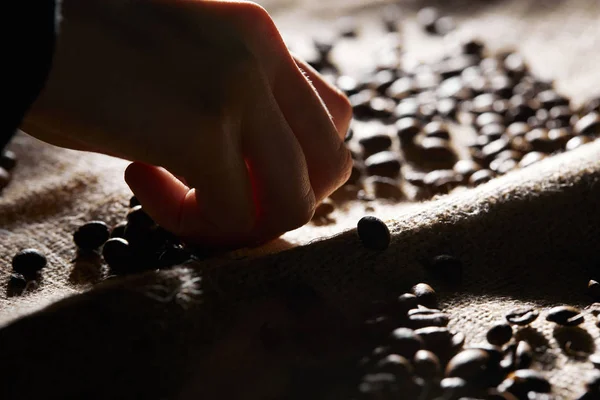 Vista parziale della donna e chicchi di caffè su sacco — Foto stock