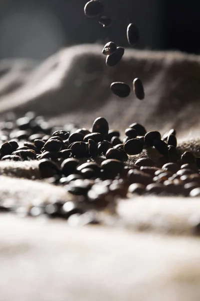 Selective focus of roasted coffee grains on sackcloth texture — Stock Photo