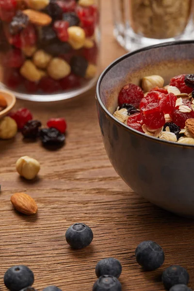 Close up of berries, nuts and muesli for breakfast on wooden table — Stock Photo