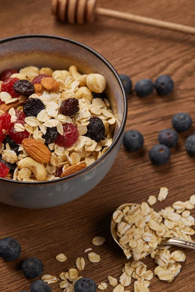 Close up of berries, nuts and muesli in bowl for breakfast on wooden table — Stock Photo