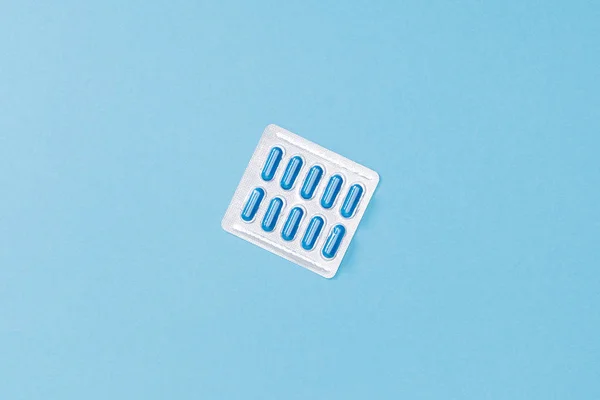 Top view of blister with pills on blue surface — Stock Photo