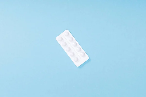 Top view of blister with pills on blue surface — Stock Photo