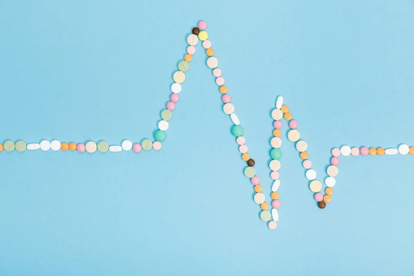 Flat lay with colorful pills on blue surface — Stock Photo