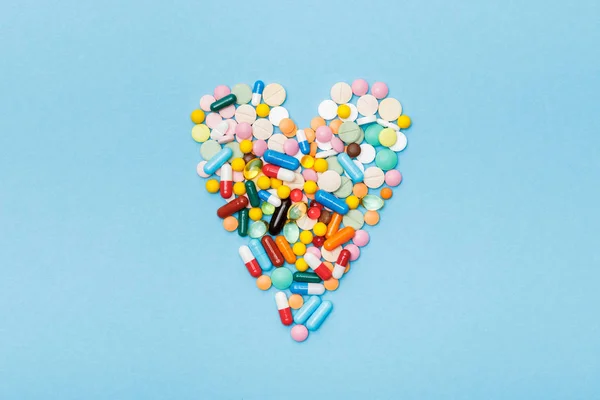 Flat lay with colorful pills on blue surface — Stock Photo