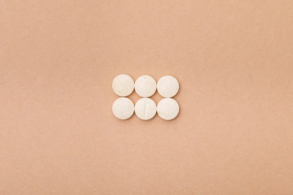 Top view of white pills on brown surface — Stock Photo