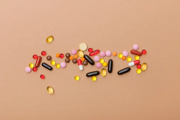 Top view of colorful pills on brown surface — Stock Photo