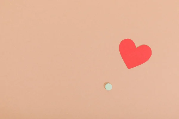Top view of paper heart and pill on brown surface — Stock Photo
