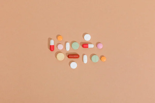 Top view of colorful pills on brown surface — Stock Photo