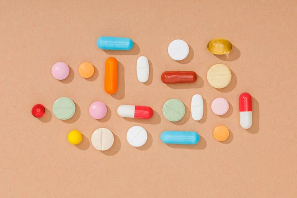 Top view of colorful pills on brown surface — Stock Photo