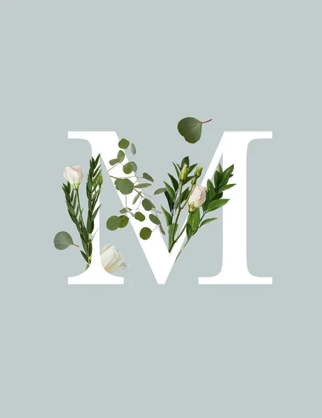 Letra blanca M con flores y hojas verdes aisladas en gris - foto de stock