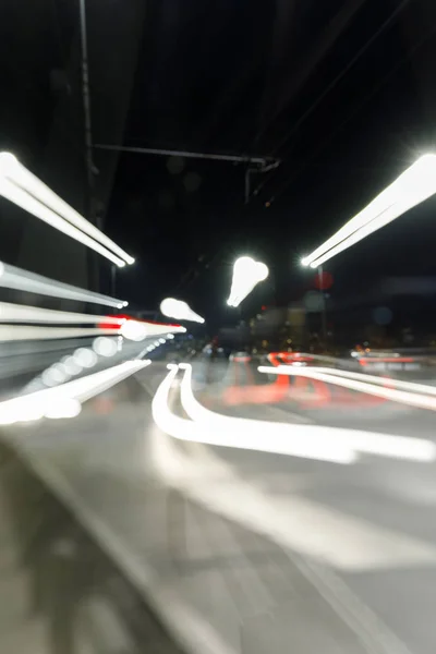 Larga exposición de luces brillantes en la carretera ocupada por la noche en la ciudad - foto de stock