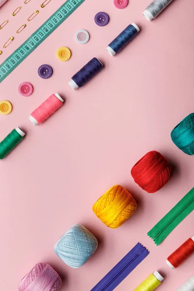 Vista superior de las bolas de hilo de punto, hilos y suministros de costura aislados en rosa con espacio para copiar - foto de stock