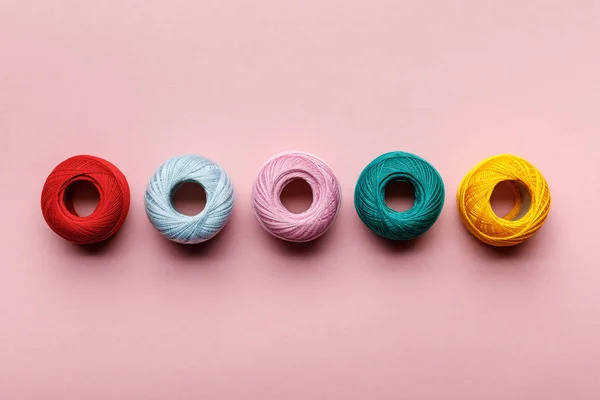 Top view of arranged colorful cotton knitting yarn balls on pink — Stock Photo