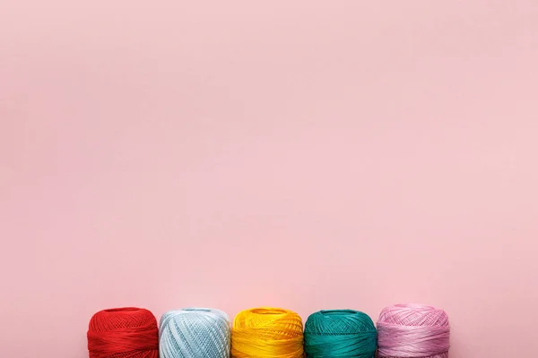 Top view of arranged colorful cotton knitting yarn balls isolated on pink with copy space — Stock Photo