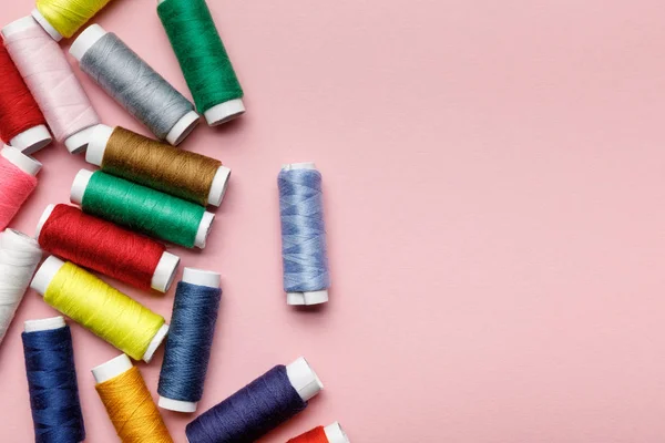 Top view of scattered colorful thread coils isolated on pink with copy space — Stock Photo