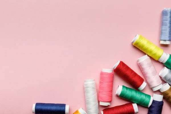 Draufsicht auf verstreute bunte Fadenspulen isoliert auf rosa mit Kopierraum — Stockfoto