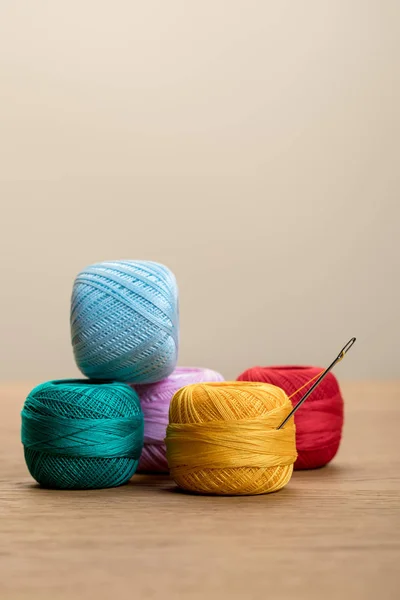 Bolas de hilo de punto de algodón colorido en la mesa de madera aislado en beige con espacio de copia - foto de stock