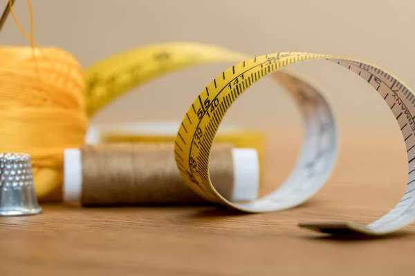 Mise au point sélective de ruban à mesurer avec bobine de fil sur table en bois — Photo de stock