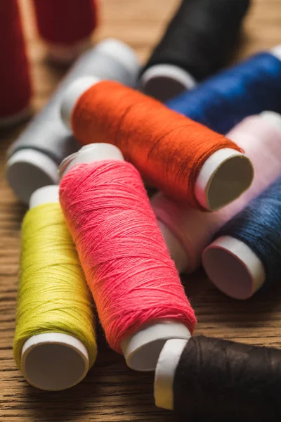 Vue rapprochée des bobines de fil de coton coloré dispersées — Photo de stock