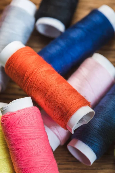 Vue rapprochée des bobines de fil de coton coloré dispersées — Photo de stock