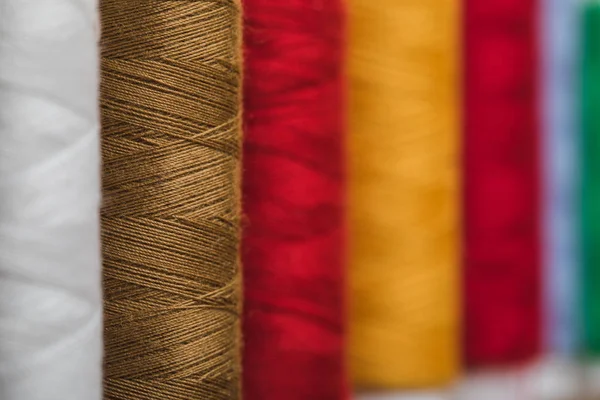 Selective focus of colorful cotton thread coils in row with copy space — Stock Photo