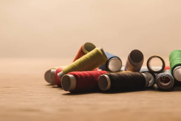 Selective focus of colorful cotton thread coils on table isolated on beige — Stock Photo