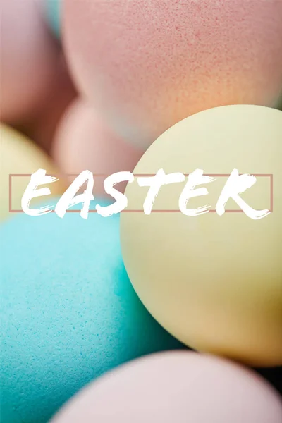 Close up of pile of multicolored painted chicken eggs with Easter lettering — Stock Photo