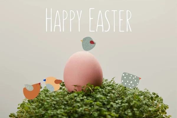 Ovo de galinha pintado rosa na grama verde com letras felizes Páscoa e pássaros ilustração no fundo cinza — Fotografia de Stock