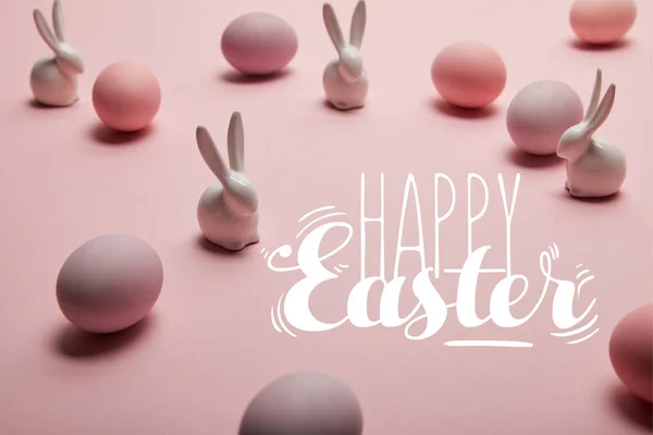 Pink painted chicken eggs with decorative rabbits and happy Easter lettering — Stock Photo