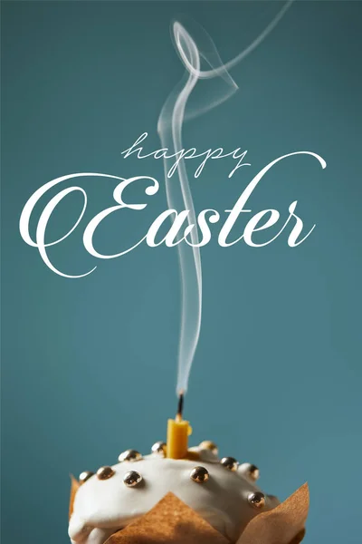 Traditional Easter cake with fireless candle and smoke on blue background with happy easter lettering — Stock Photo