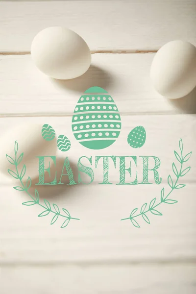 Chicken eggs on white wooden table with turquoise Easter lettering — Stock Photo