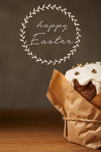 Close up of traditional Easter cake in craft paper with happy easter lettering — Stock Photo