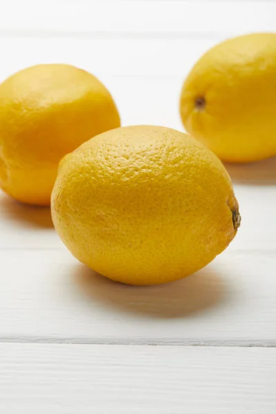 Délicieux citrons bio mûrs sur table en bois blanc — Photo de stock