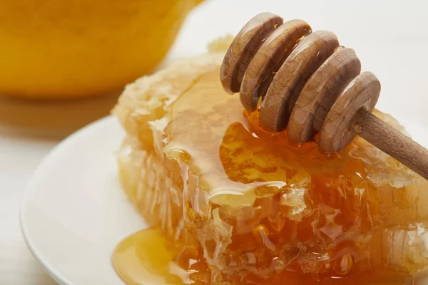 Nahaufnahme von köstlichen Waben und hölzernem Honigtropfer auf Teller — Stockfoto