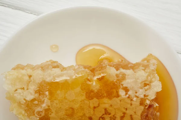 Vista superior da placa com delicioso favo de mel na mesa branca — Fotografia de Stock