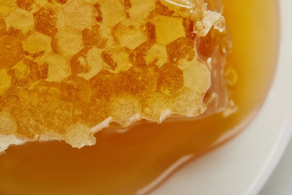 Fundo de delicioso cru texturizado favo de mel na placa — Fotografia de Stock
