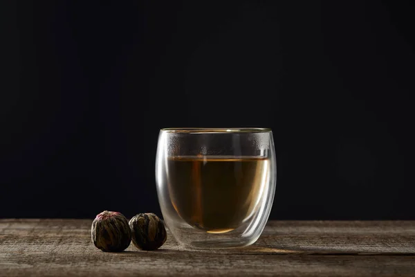 Transparentes Glas mit blühendem Tee isoliert auf schwarz mit Kopierraum — Stockfoto