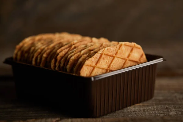 Enfoque selectivo de deliciosos gofres finos en recipiente en mesa de madera - foto de stock