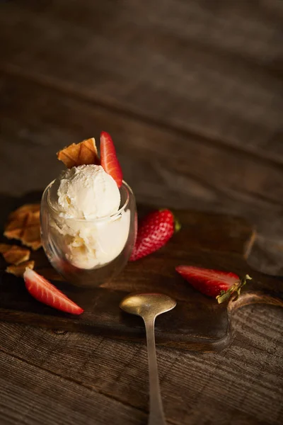 Ice cream with strawberries and waffle pieces in glass and spoon on wooden table with copy space — Stock Photo