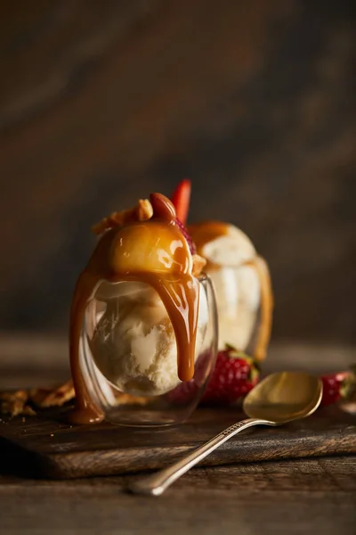 Delicious ice cream with caramel in glass on chopping board — Stock Photo