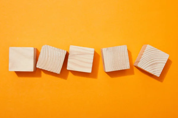 Vista superior de bloques de madera en la superficie naranja - foto de stock