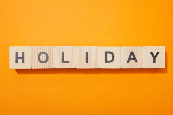 Vista superior de bloques de madera con letras en la superficie naranja - foto de stock