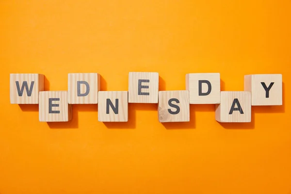 Top view of wooden blocks with letters on orange surface — Stock Photo